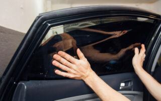 hands applying window tint