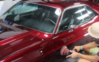 man detailing red car
